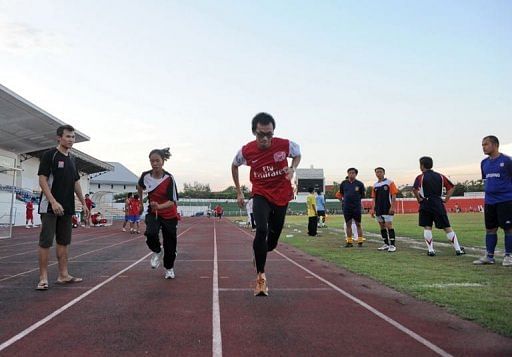 Coach Chaleunsouk Aoudomphanh (L) watches athletes Kilakone Siphonexay (3rd L) and Lealy Phoukhavont (2nd L)